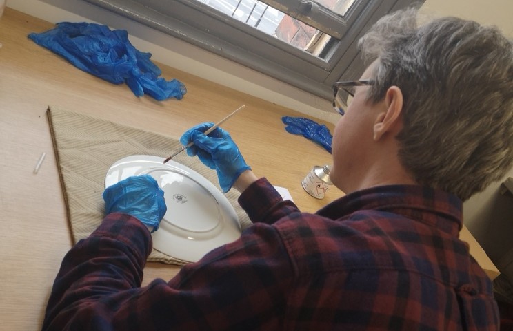 Curator repairing a plate